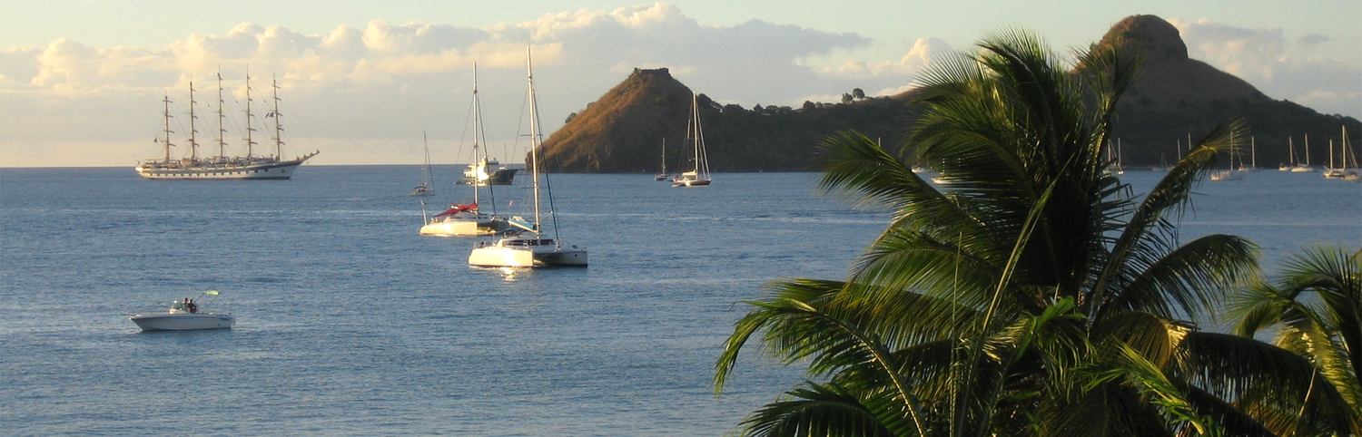 View of a great expanse of ocean with sail boats taken from the shores of Saint Lucia