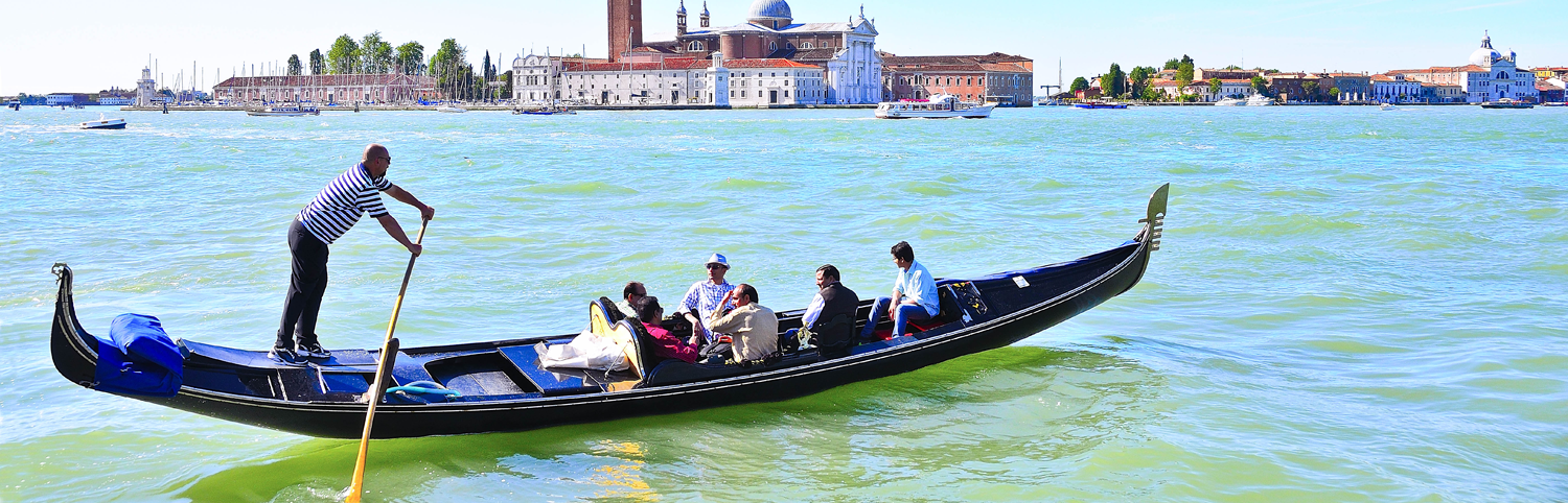 5 people on a gondola flotilla ride in Venice