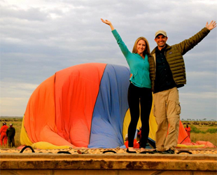 Young couple waving in Maasai Mara National Reserve in Kenya