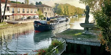 Judy sitting on a hotel barge, cruising on a river in France