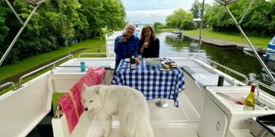 Couple engoing drinks and snacks on the deck of a houseboat