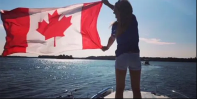 Small Ship Cruising-the shadow of a person on the bow of a ship holding the canadian flag